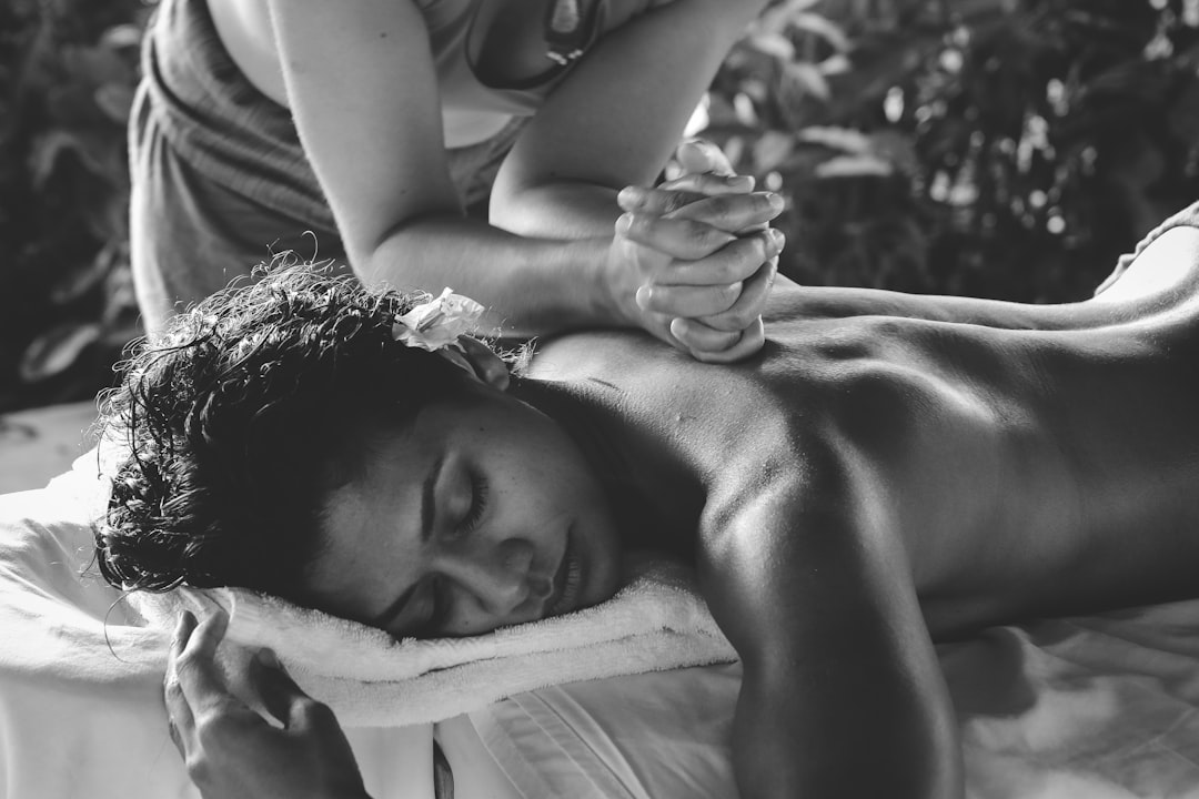 woman lying on blue towel with white cream on face