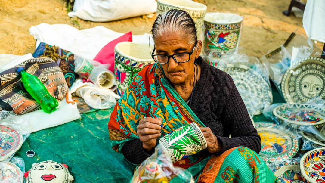 a woman sitting in front of a pile of pottery